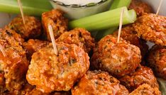 meatballs and celery with toothpicks in a bowl on a table