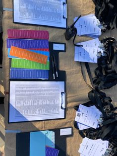 several binders and papers laid out on top of a table next to each other