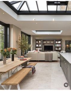 a large open kitchen and living room with skylights