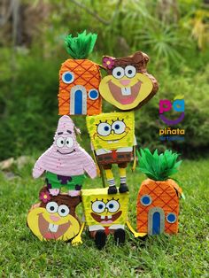 an assortment of paper cut out toys in the grass with pineapples and other decorations