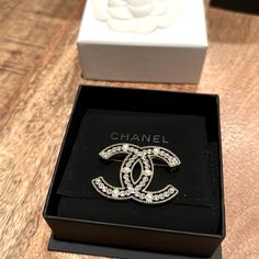 Preowned. In Original Box. Excellent Condition. Limited Edition Chanel Brooch. 6 Pearls And 38 Rhinestones. Classic White Diamond Brooches, Classic White Brooches For Evening, Classic White Evening Brooches, Luxury Brooches With Diamond Accents, Luxury Diamond White Brooch Jewelry, Luxury Diamond White Brooch, Elegant Brooch With Diamond Accents As Gift, Elegant Diamond Accents Brooch For Gift, White Rhinestone Brooches For Formal Occasions