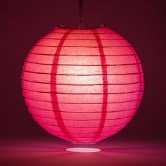 a large pink paper lantern lit up in the dark