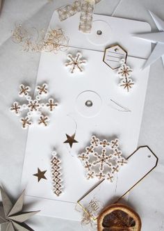 some ornaments are laying out on top of a piece of white paper and star decorations