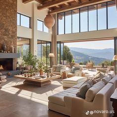 a living room filled with furniture and a fire place in front of a large window