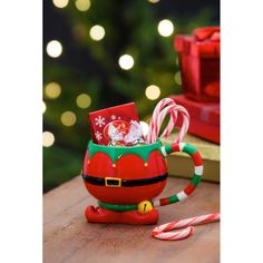 a christmas mug filled with candy canes on top of a table