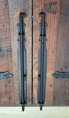 two black iron handles on wooden doors