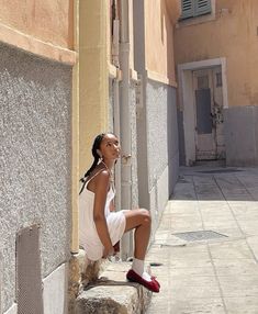 a woman sitting on the side of a building