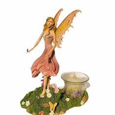 a figurine of a fairy holding a wand on top of a flower pot