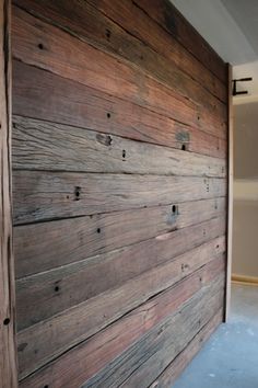 an empty room with wood paneling on the wall