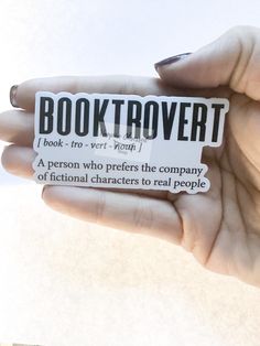 a person holding up a sticker that says booktrover