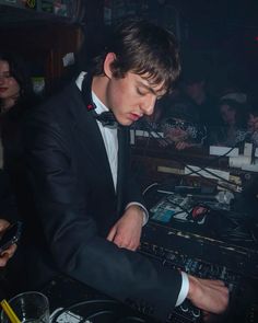 a young man in a tuxedo mixing music