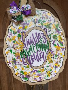 a wreath that has been decorated with flowers and words in purple, green, yellow and white