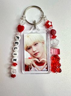 a keychain with a picture of a boy on the front and red beads around it