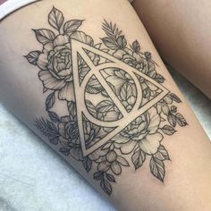 a woman's thigh with a flower and triangle tattoo on it