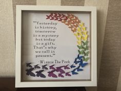 a framed paper art with a poem written in rainbow colors and butterflies on the bottom