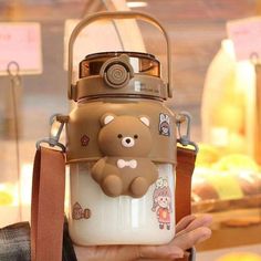 a person holding up a brown and white bear water bottle