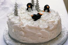 a cake with frosting and penguins on top