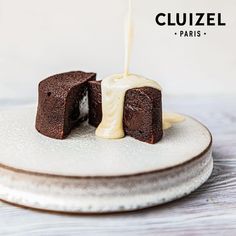 a piece of chocolate cake on a plate with a drizzle of white icing