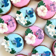 there are many decorated doughnuts on the table with blue frosting and pink icing