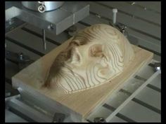 a wooden carving in the shape of a face on a piece of wood being made