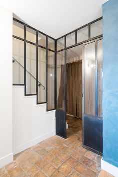 an empty room with blue walls and glass doors