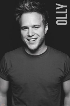 a man smiling while standing in front of a black and white poster with the words city on it