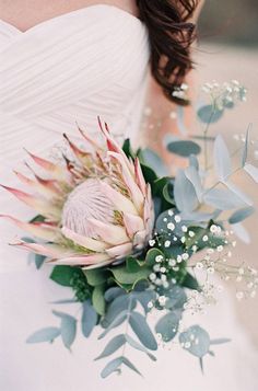 a woman holding a bouquet of flowers in her hand