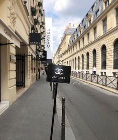 an empty street lined with tall buildings in the background and a sign that says voitlier on it