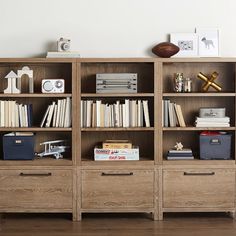 a bookshelf filled with lots of books on top of a hard wood floor