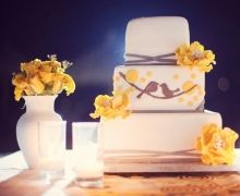 a wedding cake with yellow flowers on the table