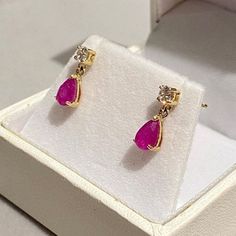 Give your loved one the ultimate gift, a pair of classic genuine Ruby set earrings set within UK hallmarked 9ct Yellow Gold.  A dainty classic design, little drops, just stunning! RUBY & SAPPHIRE are available for 2-3 days delivery ... we are busy making further pairs using our other gemstones... those will take a few weeks i'm afraid. Metal: Solid 9ct Yellow Gold ( Fully Hallmarked )   Info: Nickel Free Stone: Genuine Red Ruby, Pear Cut & Simulated Diamond Free Gift: Jewellery Polishing Cloth Quantity: Sold as a pair Type: Specifically designed for the lobe Size: Total length 12mm  Fixing: 9ct Hallmarked Gold Butterfly Backs  Colour: Ruby Red / Pink NOTE: In general due to health & safety reasons, earrings are non returnable unless there is a description error, or have incurred damage in