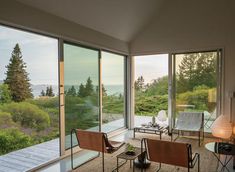 a living room filled with furniture and lots of glass doors leading to the outside deck