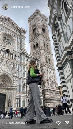 a woman standing in front of a tall building