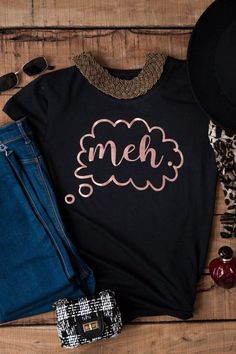 a t - shirt with the word meh on it next to jeans and shoes