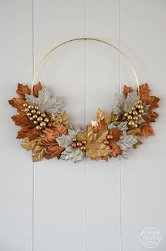 a wreath with leaves and berries hanging on the wall