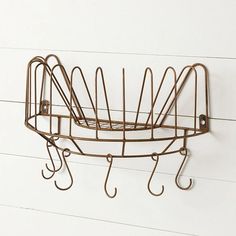 a metal rack with hooks hanging from it's sides on the wall next to a white wall