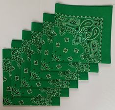 six green bandanas with paisley designs on them