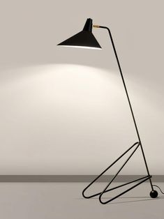 a floor lamp with a black shade on the top and a white light behind it