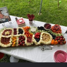 a table topped with lots of fruits and veggies on top of a white table cloth