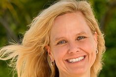 a woman with blonde hair smiling at the camera