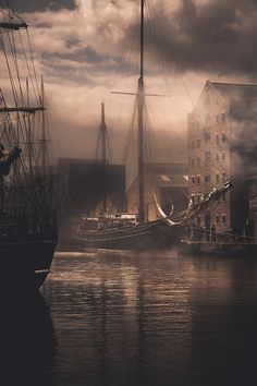 two ships in the water near buildings and clouds