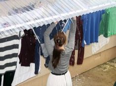 a woman standing in front of a clothing rack