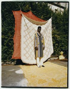 a man standing in front of a white and orange tent