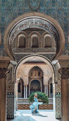 a woman sitting on the ground in an ornate building