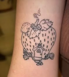 a small tattoo on the wrist of a girl with a house and strawberries in the shape of a heart