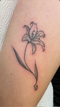 a tattoo with a flower on the left side of the arm and an arrow in the middle