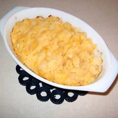 a casserole dish with cheese in it on a black and white doily