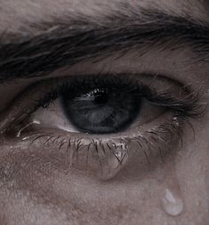 an extreme close up shot of someone's eye with water drops on the iris