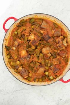 a red pot filled with food on top of a white counter