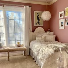 a bed room with a neatly made bed and pictures on the wall next to it